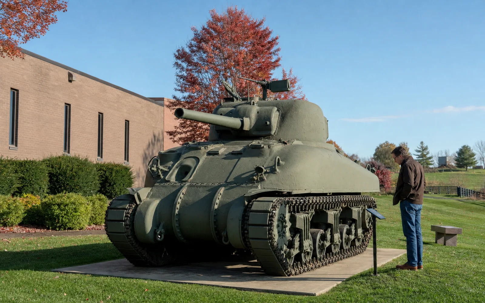 Olive-drab World War II Sherman tank on display on a lawn outside a low brick museum building on a clear autumn afternoon, AI-generated illustration